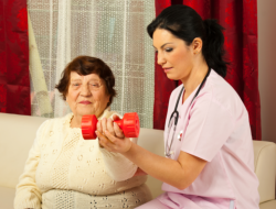nurse assisting an old woman to exercise